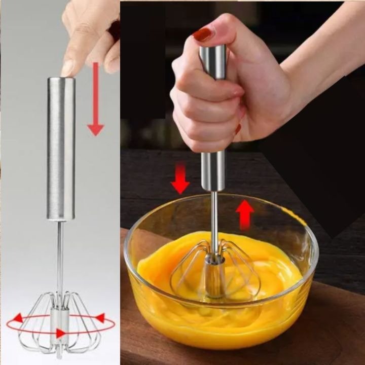 "Hand using stainless steel push whisk to mix eggs in a glass bowl – self-rotating manual egg beater with ergonomic grip"