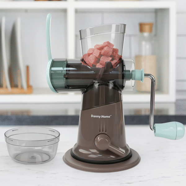 Danny Home manual meat grinder with hand crank and suction base filled with meat cubes on a kitchen counter