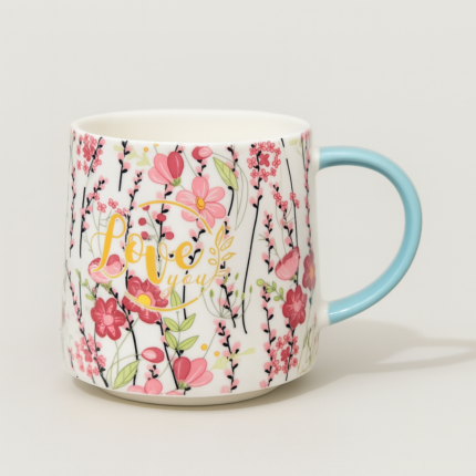 Ceramic coffee mug with pink floral design and "Love You" message, featuring a blue handle – perfect romantic gift mug for tea or coffee