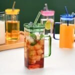 400ml square glass juice cup with colored handles and straws, durable household kitchen accessories available for wholesale rate in Pakistan.