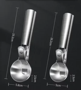 Hand holding a stainless steel ice cream scoop with trigger release over a wooden table